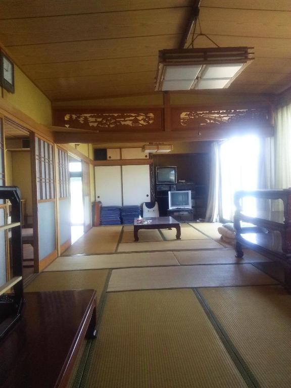 een woonkamer met een bank en een tafel bij Minshuku Kamagari in Kure