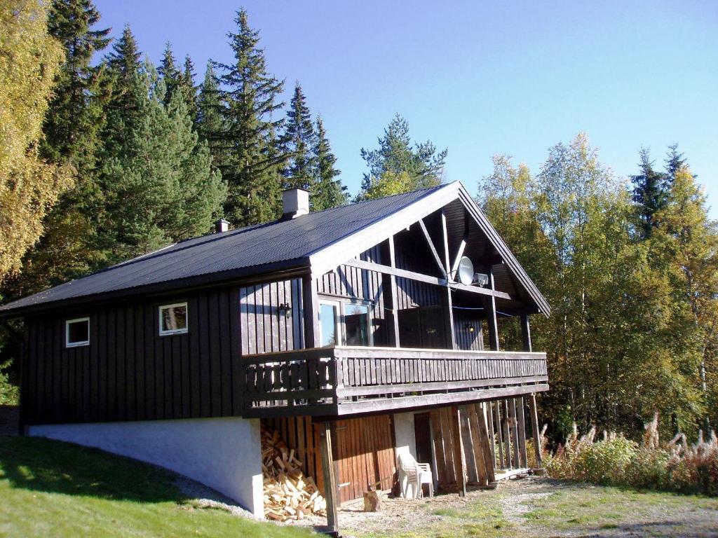 a large black house with a large deck at Hogstul Hytter - Apartment North in Tuddal