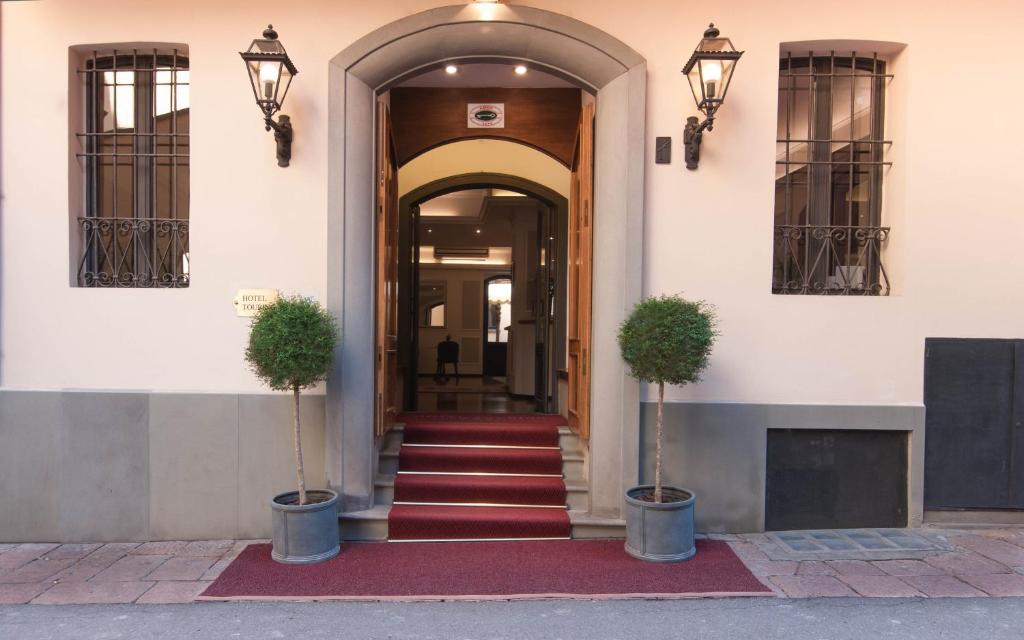 an entrance to a building with two potted plants at Hotel Touring in Bologna