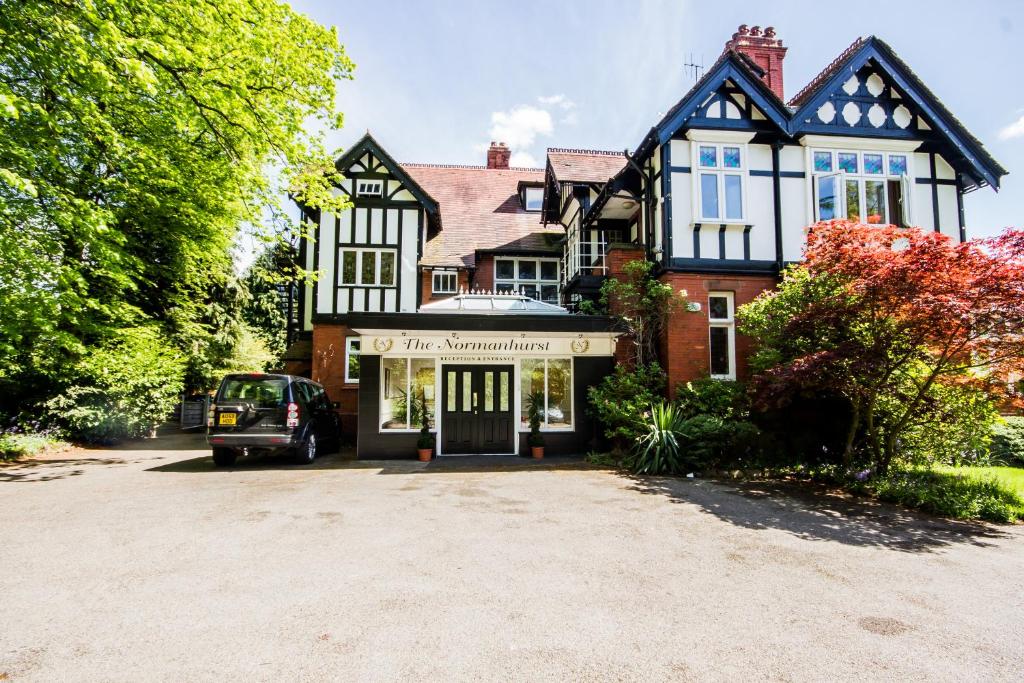 uma casa com um carro estacionado em frente em NormanHurst Hotel em Sale