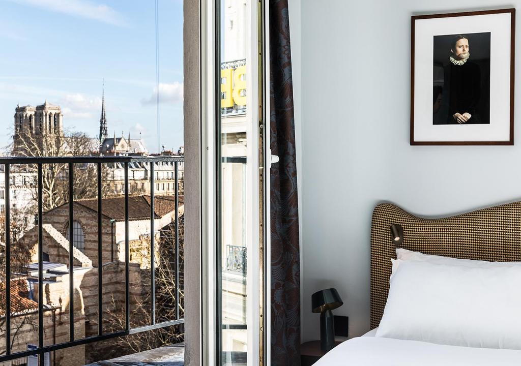 sypialnia z łóżkiem i widokiem na miasto w obiekcie Hôtel Belloy Saint Germain w Paryżu