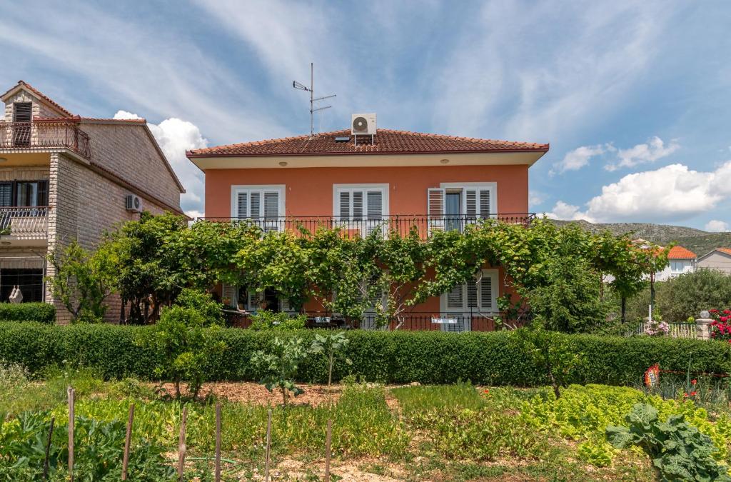 een huis met wijnstokken aan de zijkant bij Marinella in Trogir