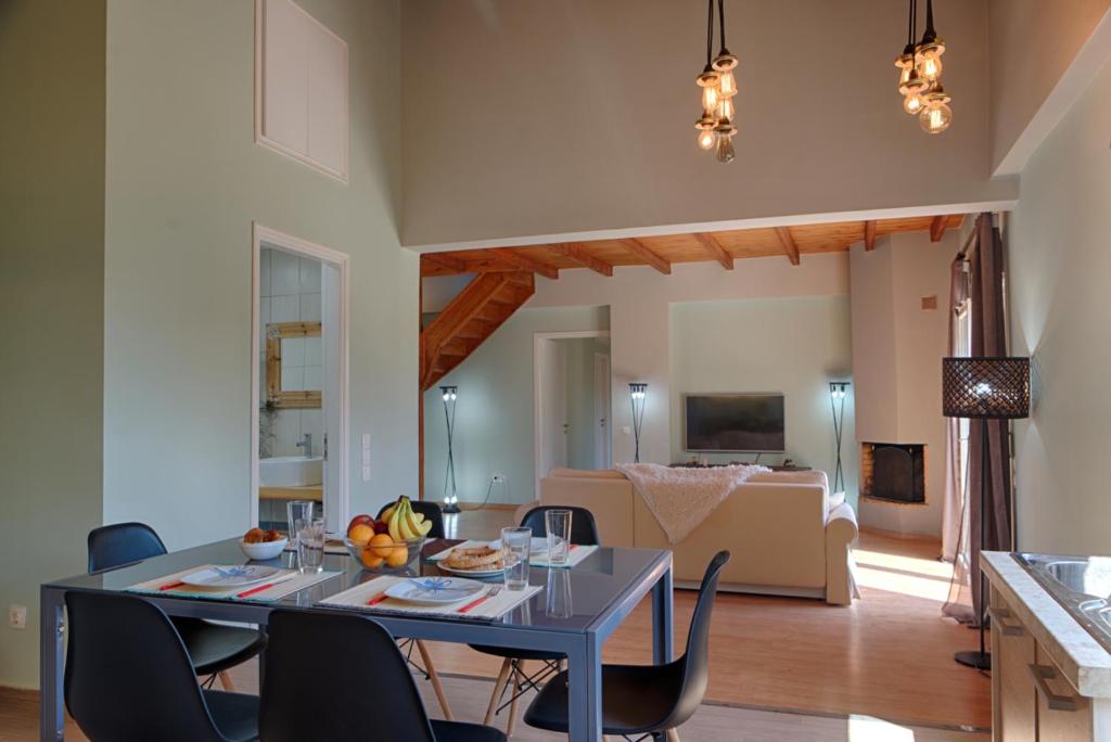 uma sala de jantar e sala de estar com mesa e cadeiras em Modern eco friendly villa close to town em Pelekas