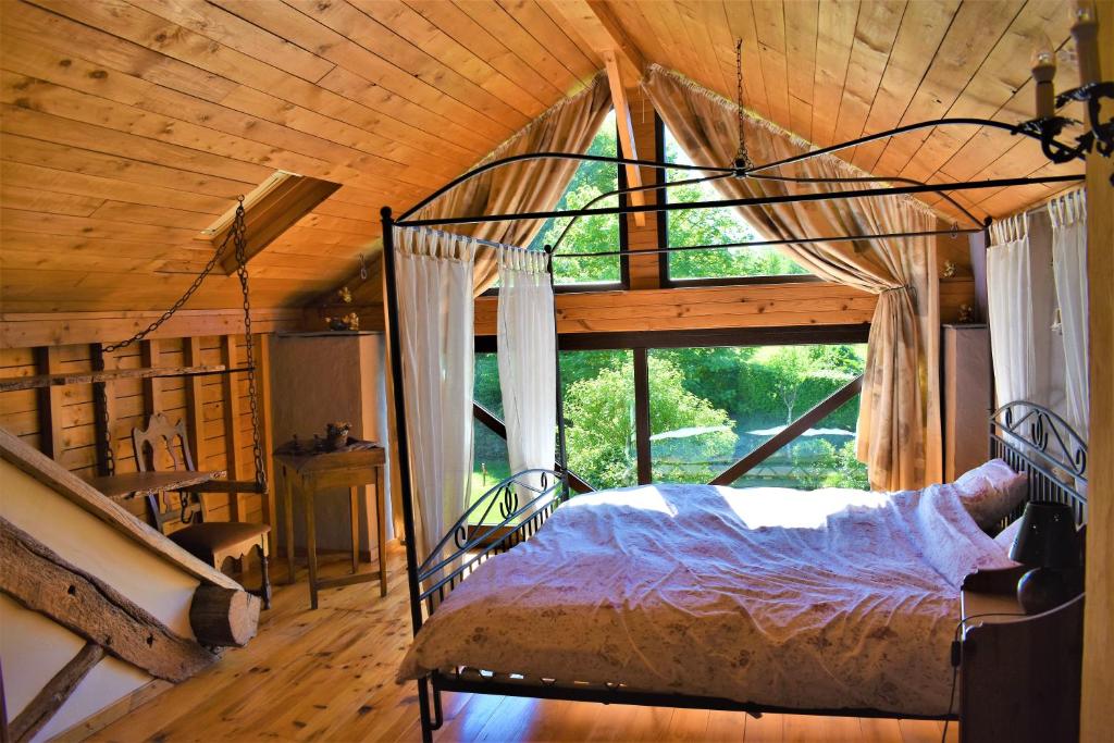 ein Schlafzimmer mit einem Bett und einem großen Fenster in der Unterkunft Gites-Clairiere-Ardenne in Louftémont