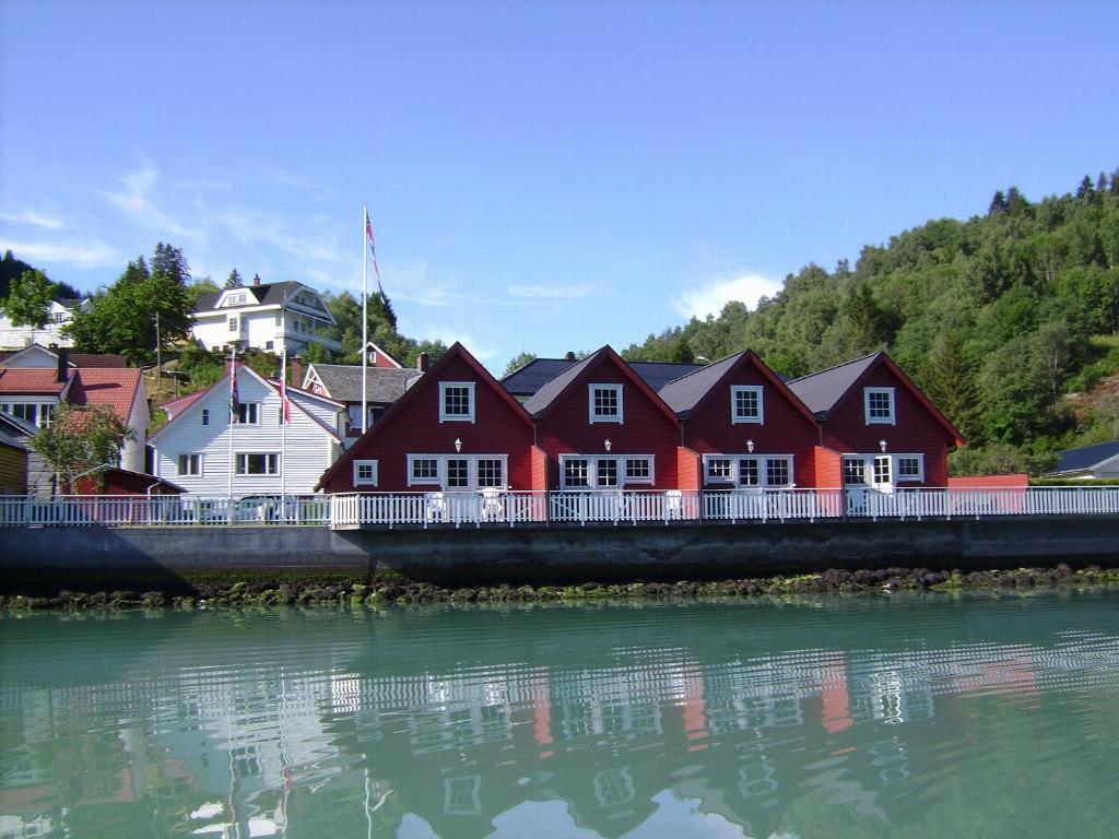 a row of red houses on a bridge over the water at Marifjøra Sjøbuer in Marifjora