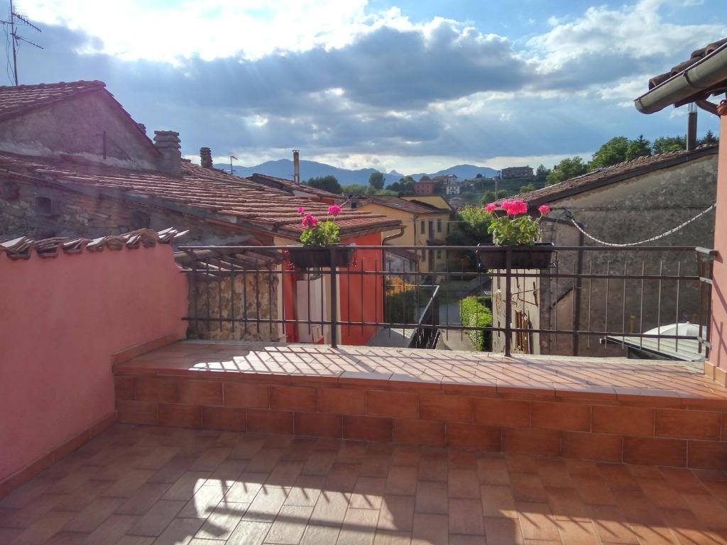 un balcón en una casa con macetas en L'Antico Borgo, en Fornaci di Barga