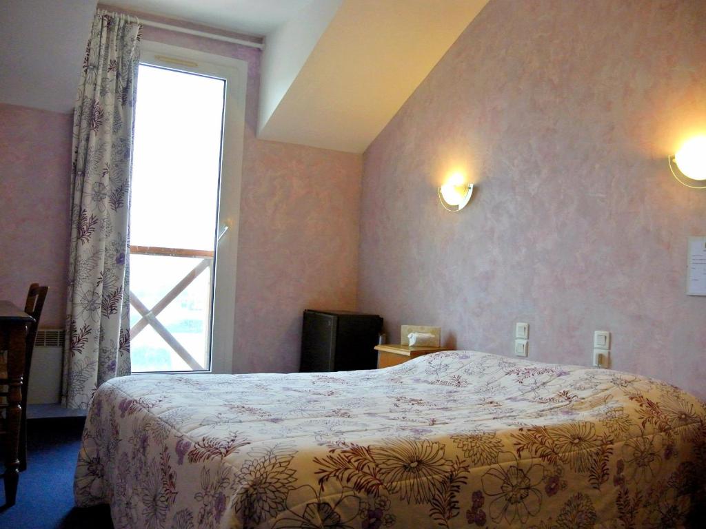 Postel nebo postele na pokoji v ubytování Logis Argonne Hôtel