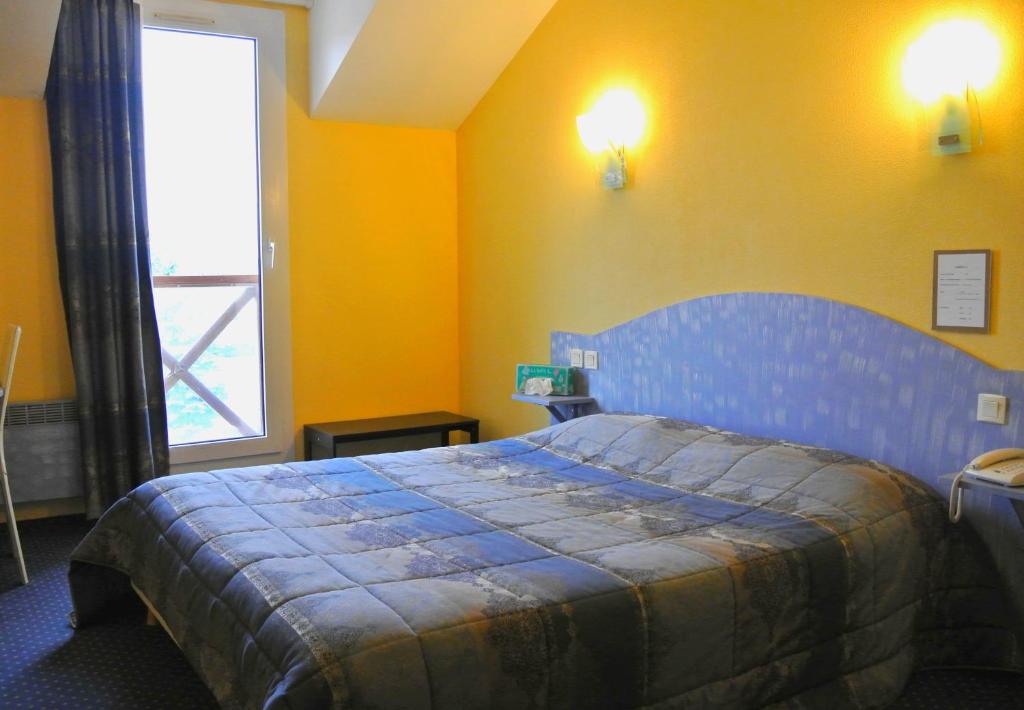 Postel nebo postele na pokoji v ubytování Logis Argonne Hôtel