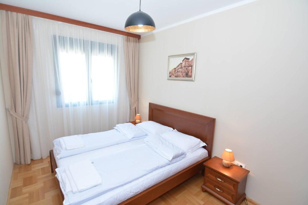 Un pat sau paturi într-o cameră la ROOMS & APARTMENTS DOBROTSKI DVORI