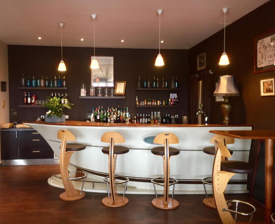 - un bar avec des chaises et un comptoir dans une pièce dans l'établissement Hôtel - Restaurant La Chaloupe, à Le Port-des-Barques