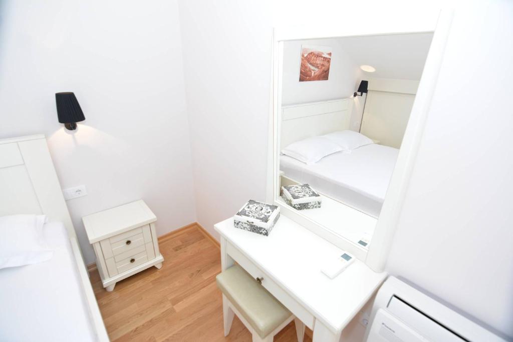 Un pat sau paturi într-o cameră la ROOMS & APARTMENTS DOBROTSKI DVORI