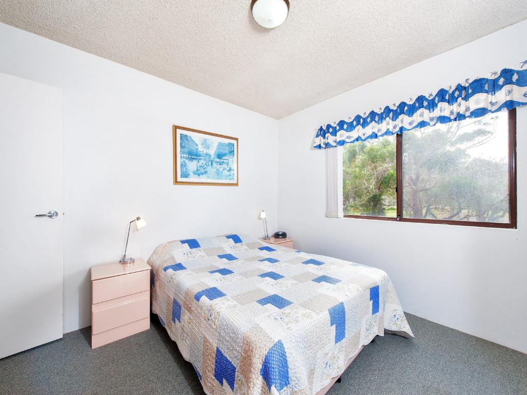 a bedroom with a bed and a window at Foreshore Paradise Nelson Bay in Nelson Bay