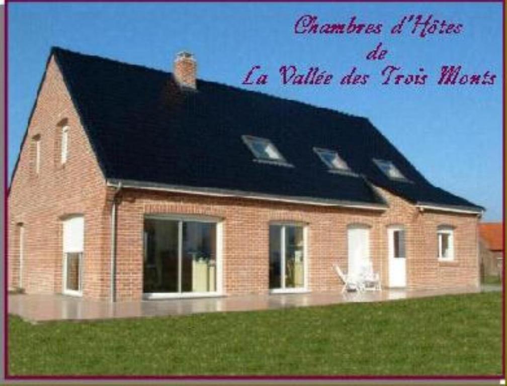 duży ceglany dom z czarnym dachem w obiekcie La Vallée des Trois Monts w mieście Saint-Sylvestre-Cappel