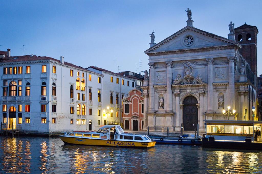 a yellow boat in the water in front of a building at Hotel Palazzo Giovanelli e Gran Canal in Venice