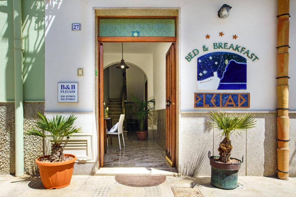 un ingresso a un edificio con due piante in vaso di B&B Pleiadi a San Vito lo Capo