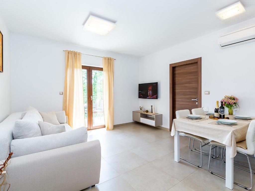 a white living room with a white couch and a table at Apartments Gioia in Poreč