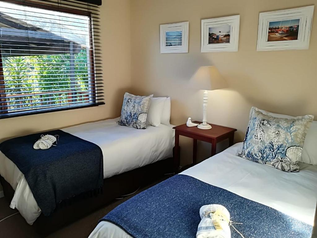a bedroom with two beds and a teddy bear on the bed at Welbedacht Estate Self catering Accommodation in Port Elizabeth