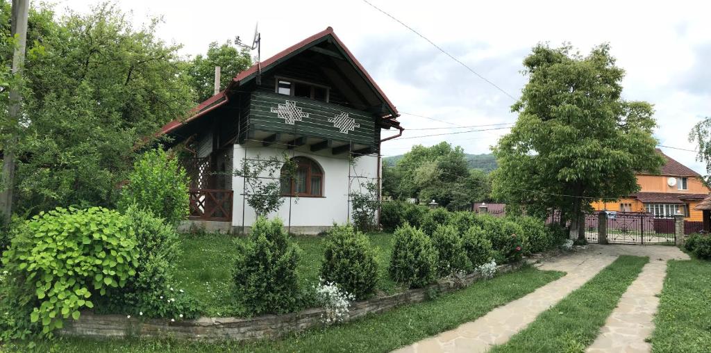 a small house in a yard with a garden at Cottage Shchaslyvyi in Yaremche