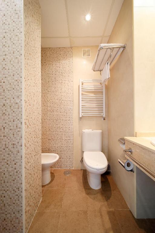 a bathroom with a toilet and a sink at Hotel Santa Rosa, Blue Hoteles in Gijón