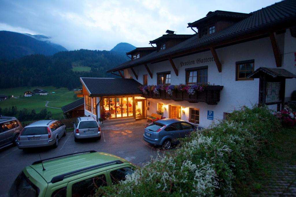 a building with cars parked in a parking lot at Pension Gatterer in Maria Luggau