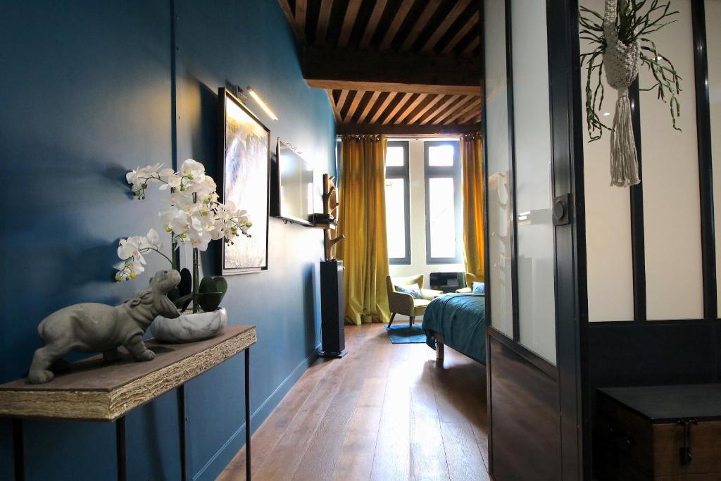 a room with a blue wall with a vase of flowers at 3e secret en plein coeur du Vieux Lyon in Lyon