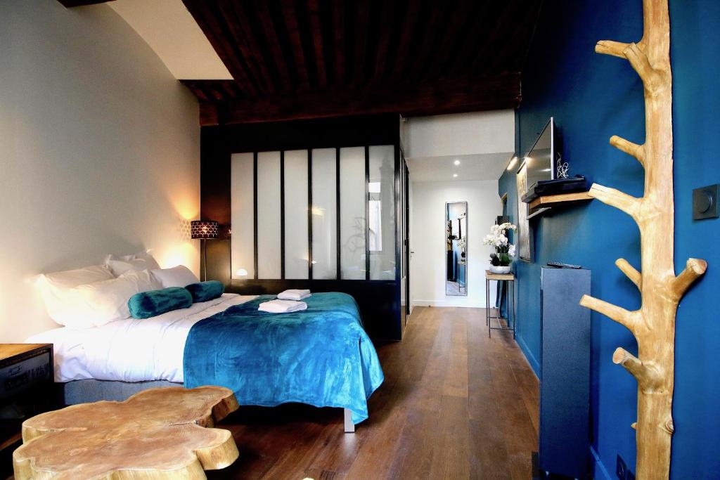 a bedroom with a bed with a blue wall at 3e secret en plein coeur du Vieux Lyon in Lyon
