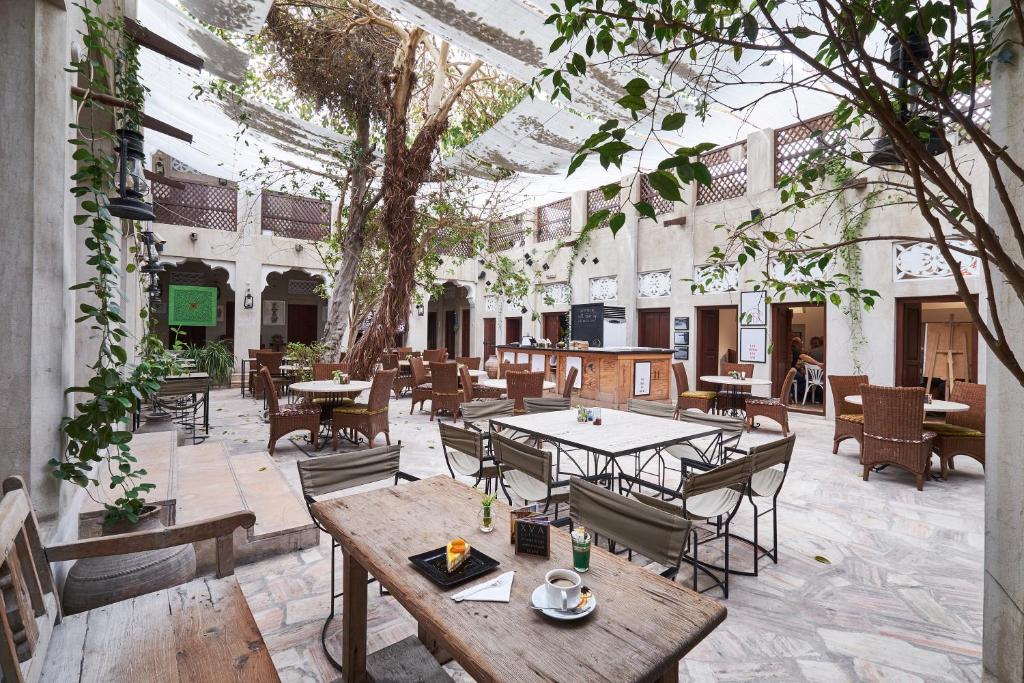 a courtyard with tables and chairs and a tree at XVA Art Hotel in Dubai