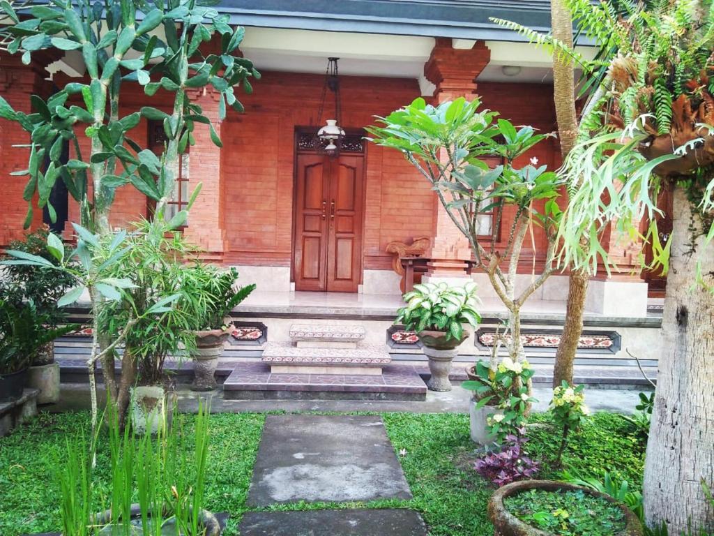 a house with a red door in a garden at Yumi House in Ubud