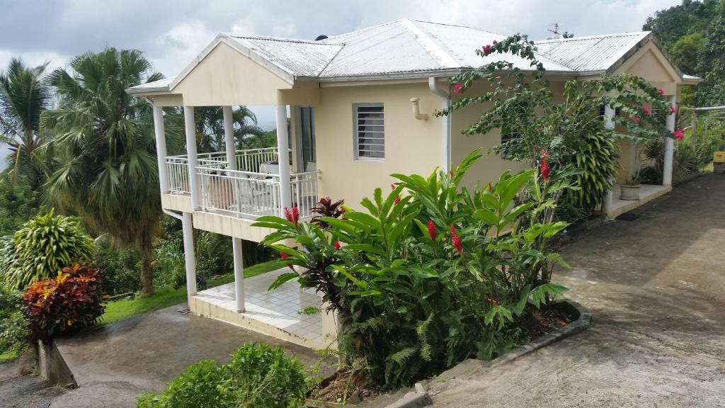 a house with a balcony and some plants at Marcus972 in Sainte-Luce