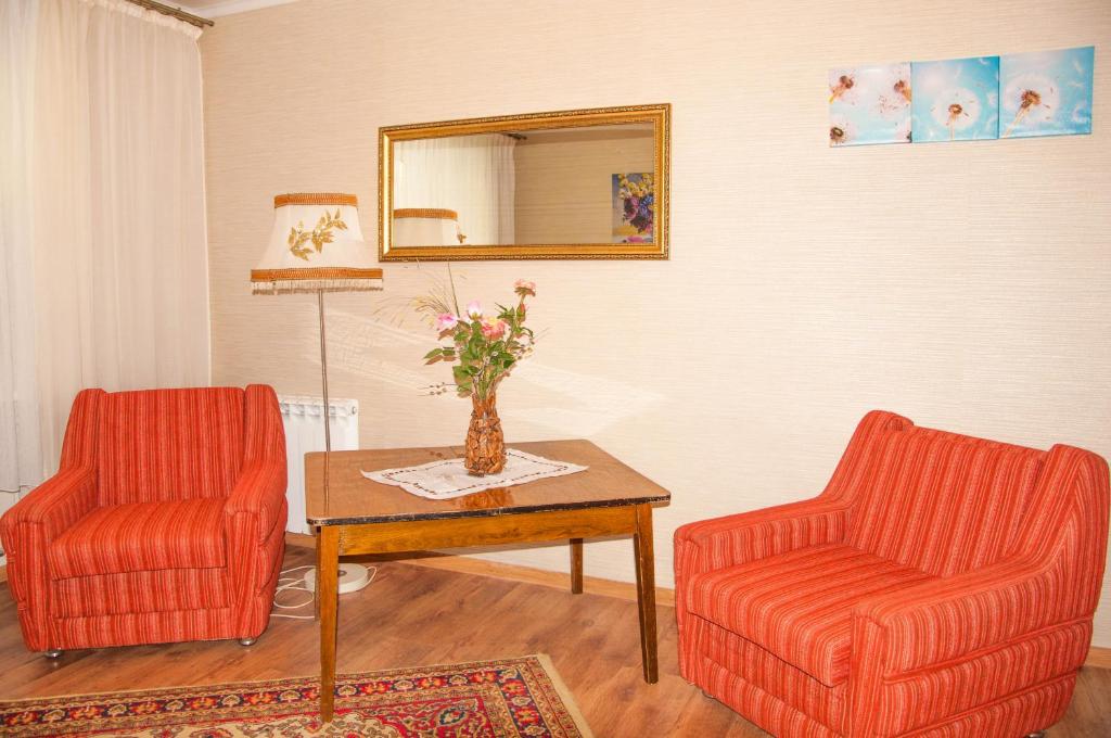 ヤロスラヴリにあるАпартаменты на Республиканскойのリビングルーム(椅子2脚、テーブル、鏡付)