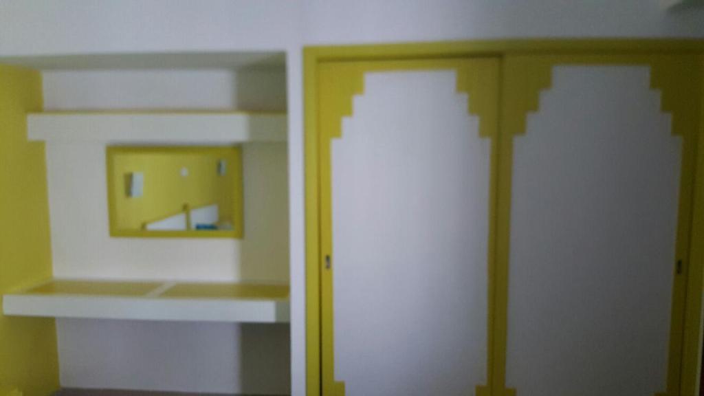 una habitación vacía con dos estanterías y una puerta en Club praia da Rocha III, en Portimão
