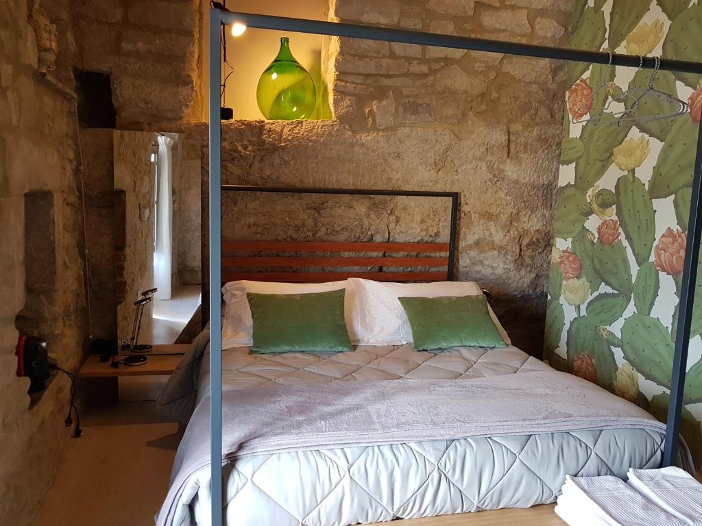 een slaapkamer met een bed met groene kussens bij Casa Santa Maria - Fichi d'india in Ragusa