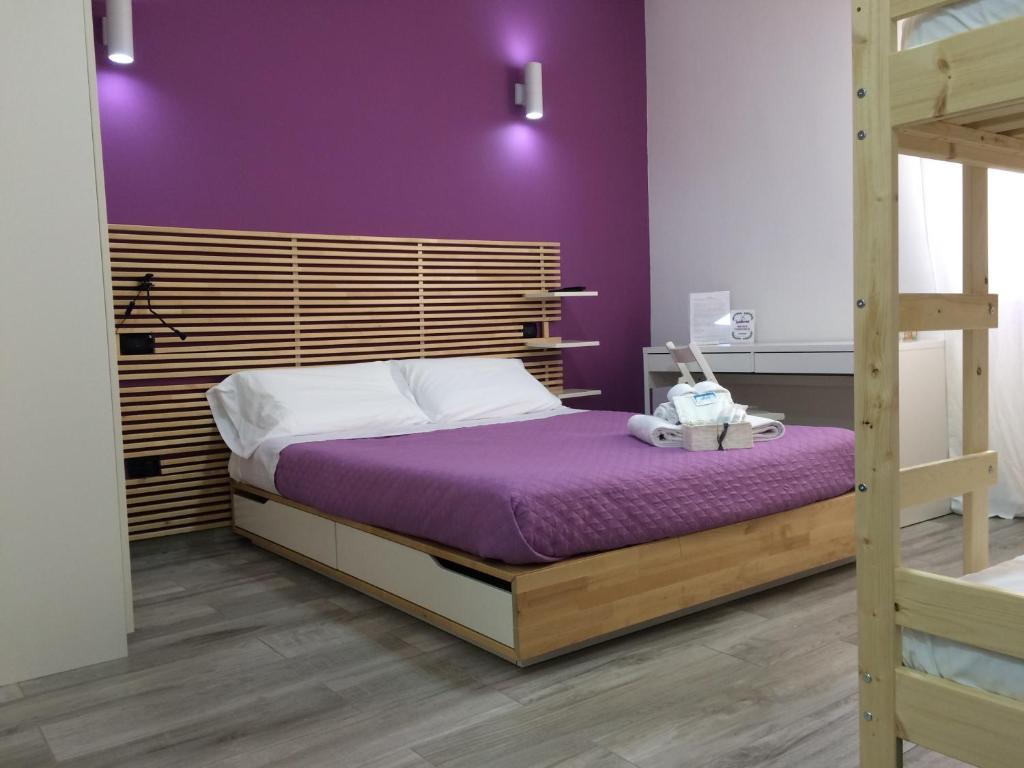 カステル・ヴォルトゥルノにある7quater B&Bの紫の壁のベッドルーム1室、二段ベッド1組が備わります。