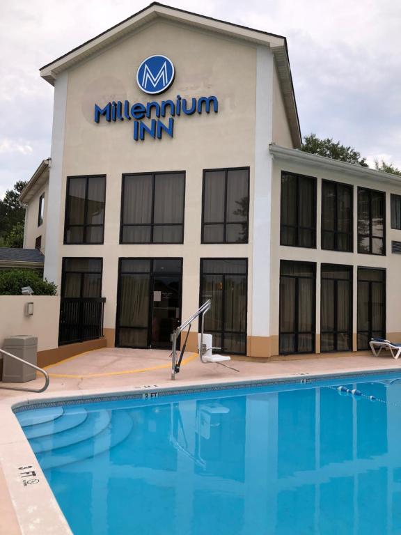 a building with a swimming pool in front of it at Millennium Inn in Ellisville