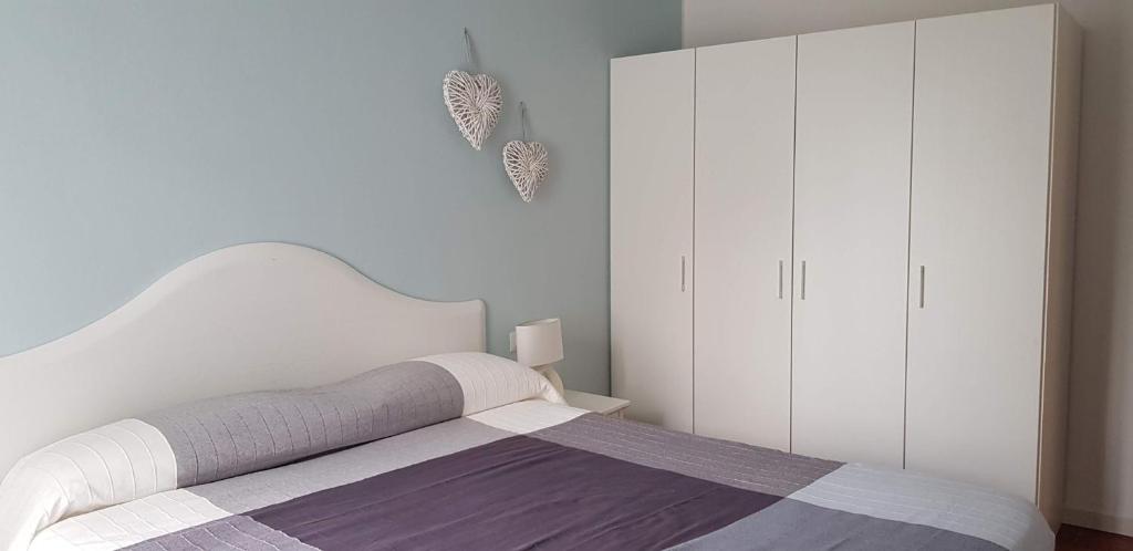 a white bedroom with a bed and white cabinets at Le Casette Di Osvaldo in Lecco