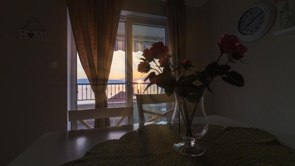 a vase of flowers sitting on a table with a window at Dida moj in Senj