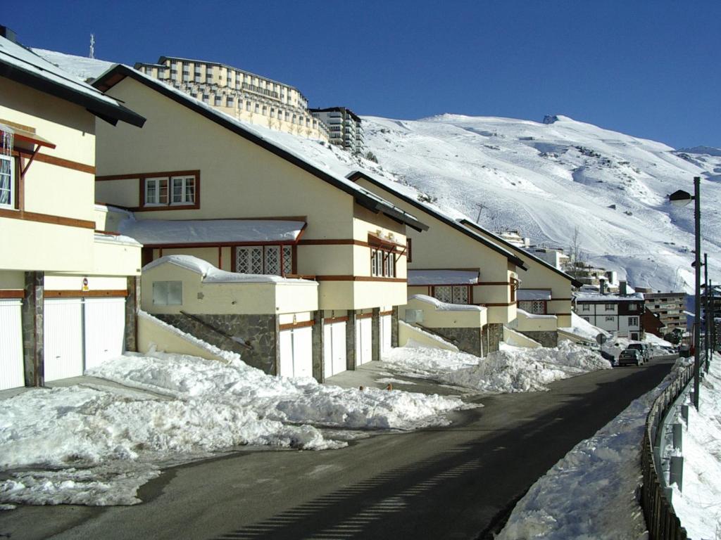 a building with snow on the side of a mountain at Apartamentos Las Tuyas in Sierra Nevada