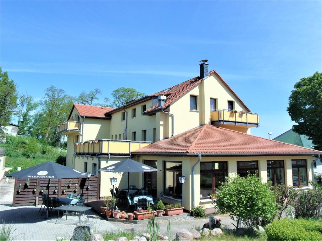 a large building with a table and chairs in front of it at Hotel Bergmühle in Bansin