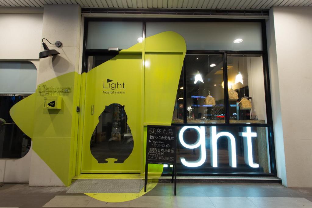 una tienda frente con una puerta verde brillante y un cartel en Let's Hostel en Kaohsiung