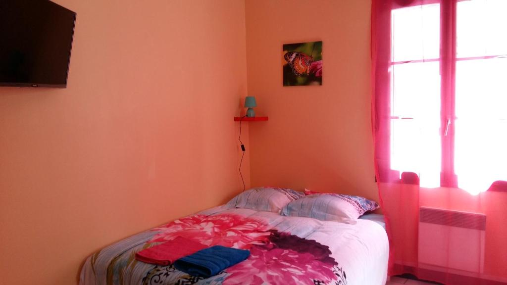 una camera da letto con un letto con pareti rosa e una finestra di Appart centre ville Auxerre ad Auxerre