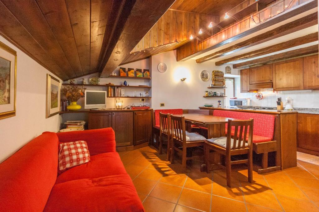 a kitchen with a red couch and a table at Casa Silva in Falcade