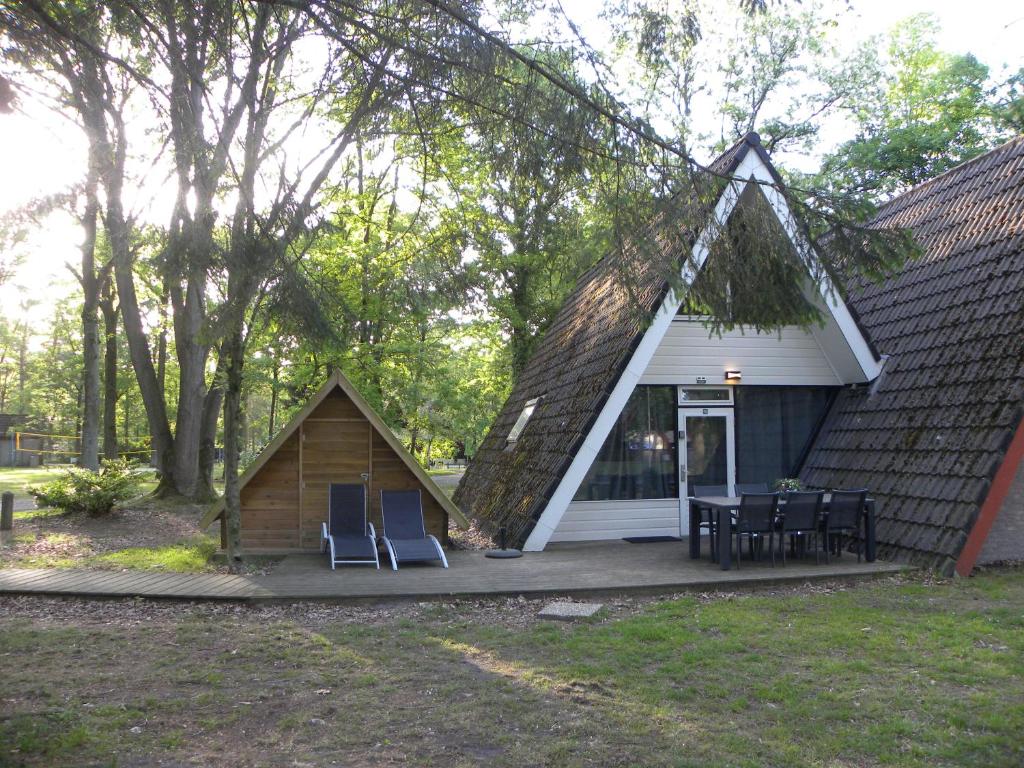 Casa pequeña con 2 sillas y mesa en Bungalows Bospark te Stramproy en Stramproy