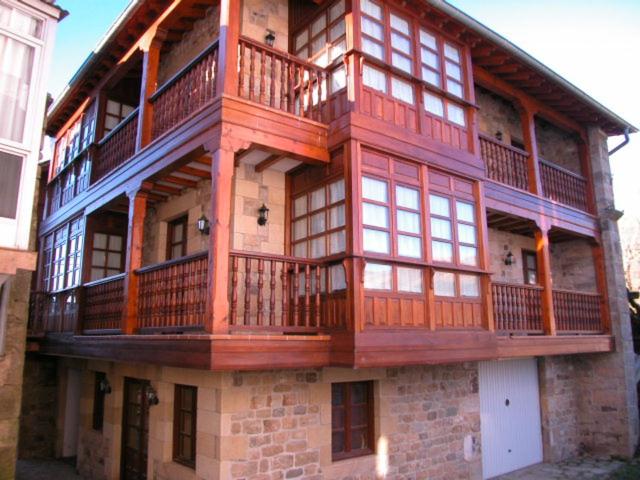 un gran edificio de madera con balcón. en Apartamento La Vieja Panadería 1, en Vega de Pas