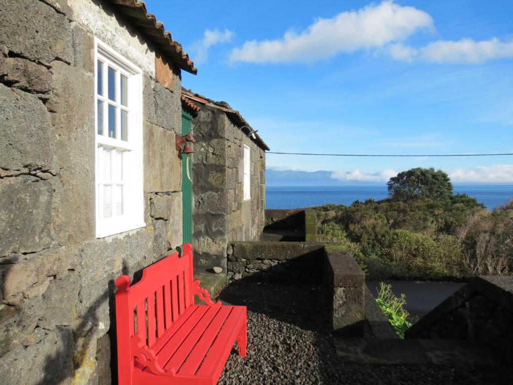 Terra Alta的住宿－Casa Adega Alto do Passinho，坐在大楼一侧的红色长凳