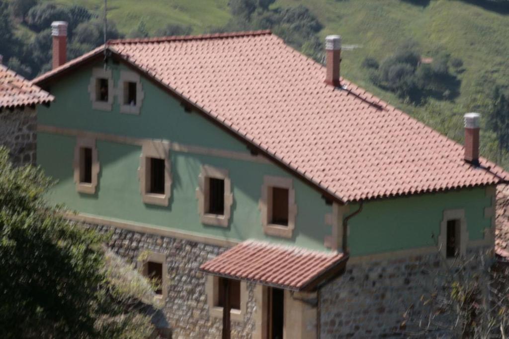 a green house with a red roof at Las Casas de Lola in Rabago