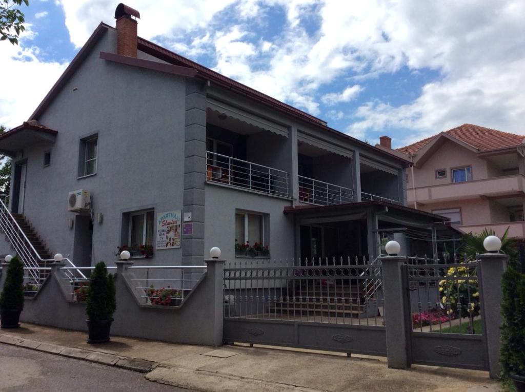 uma casa branca com um alpendre e uma varanda em Apartment Slavica em Star Dojran