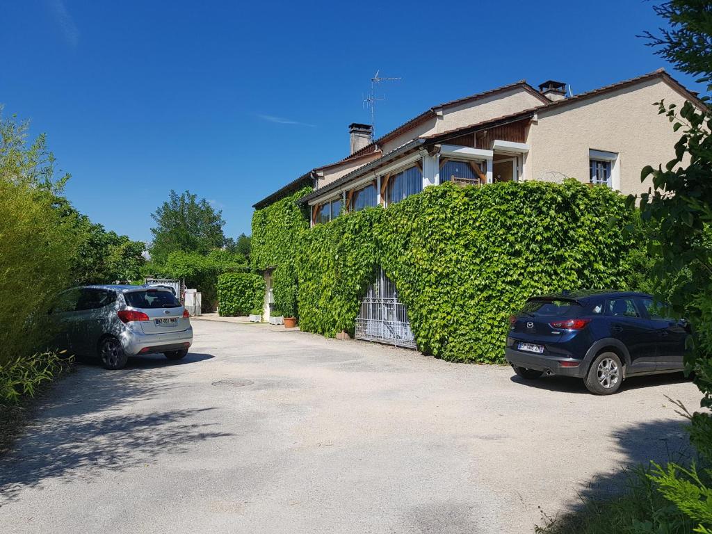 two cars parked in front of a house at Gîte Mercues in Mercuès