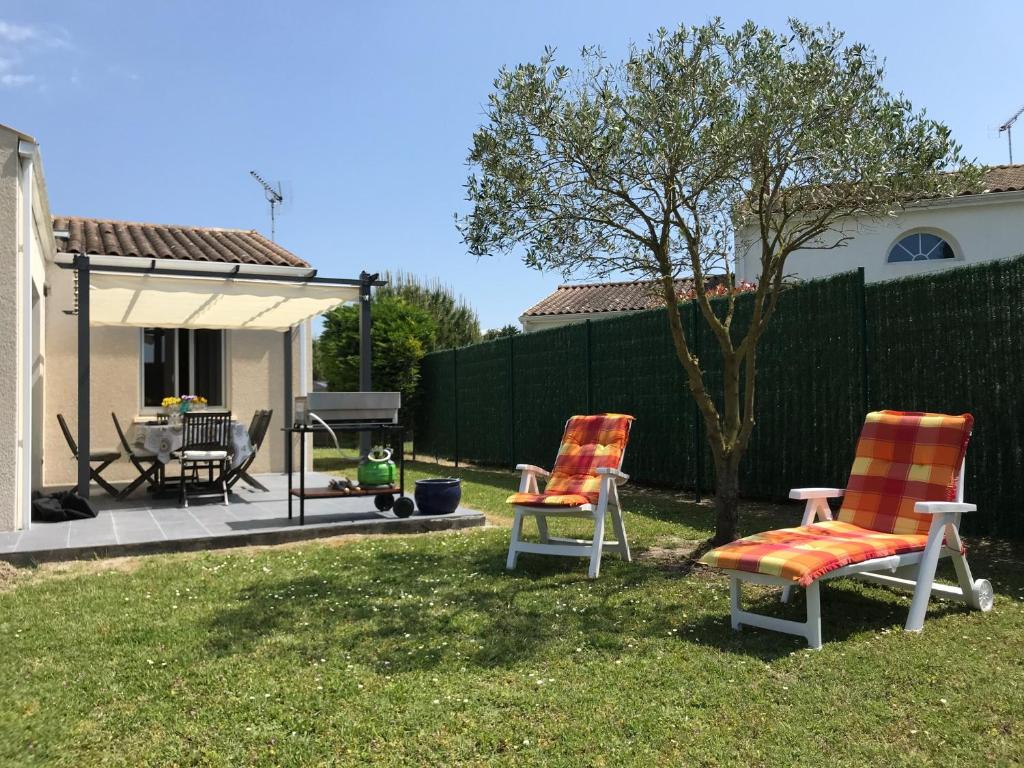 twee stoelen en een tafel in de tuin bij Belle Maison in Meschers-sur-Gironde