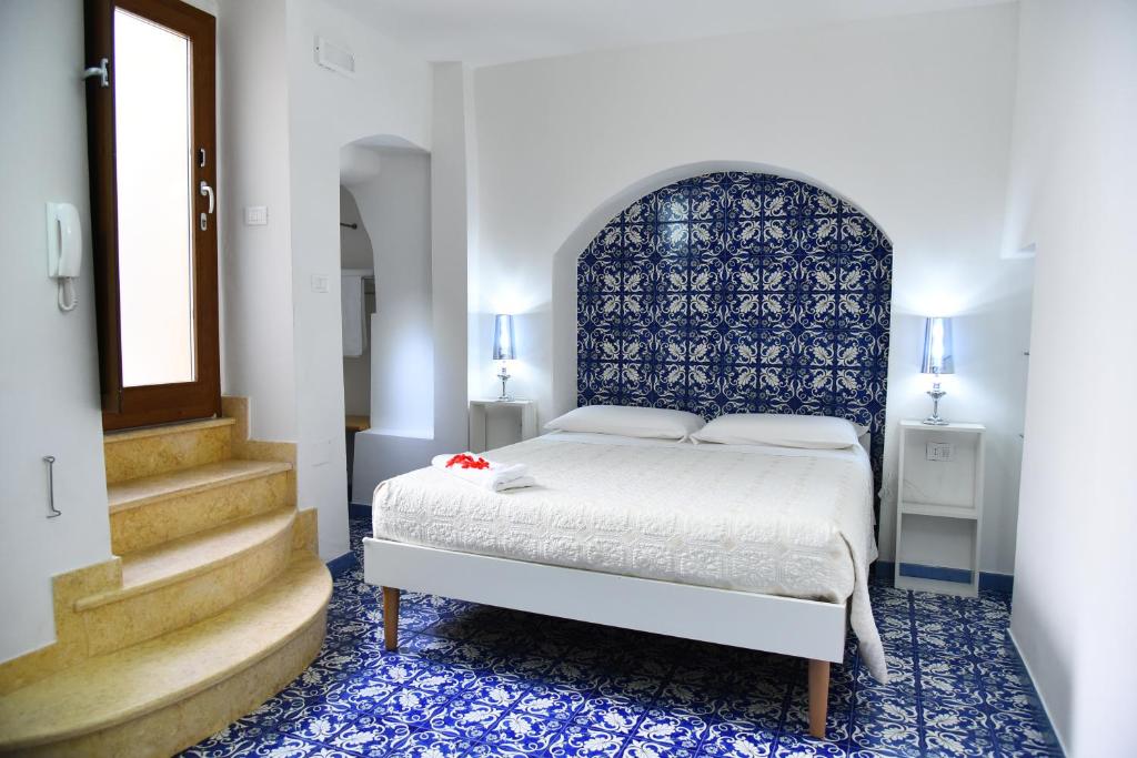 a bedroom with a bed with a blue headboard and stairs at B&B Corte Casole in Gallipoli