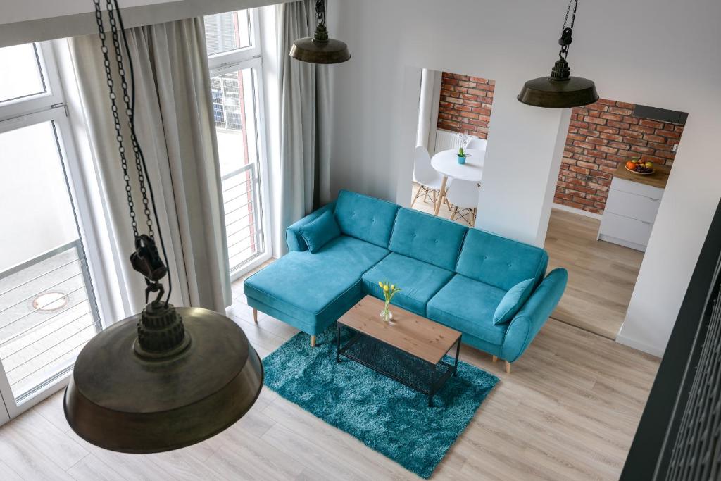 a living room with a blue couch and a table at Easy Apartments Wrocław in Wrocław
